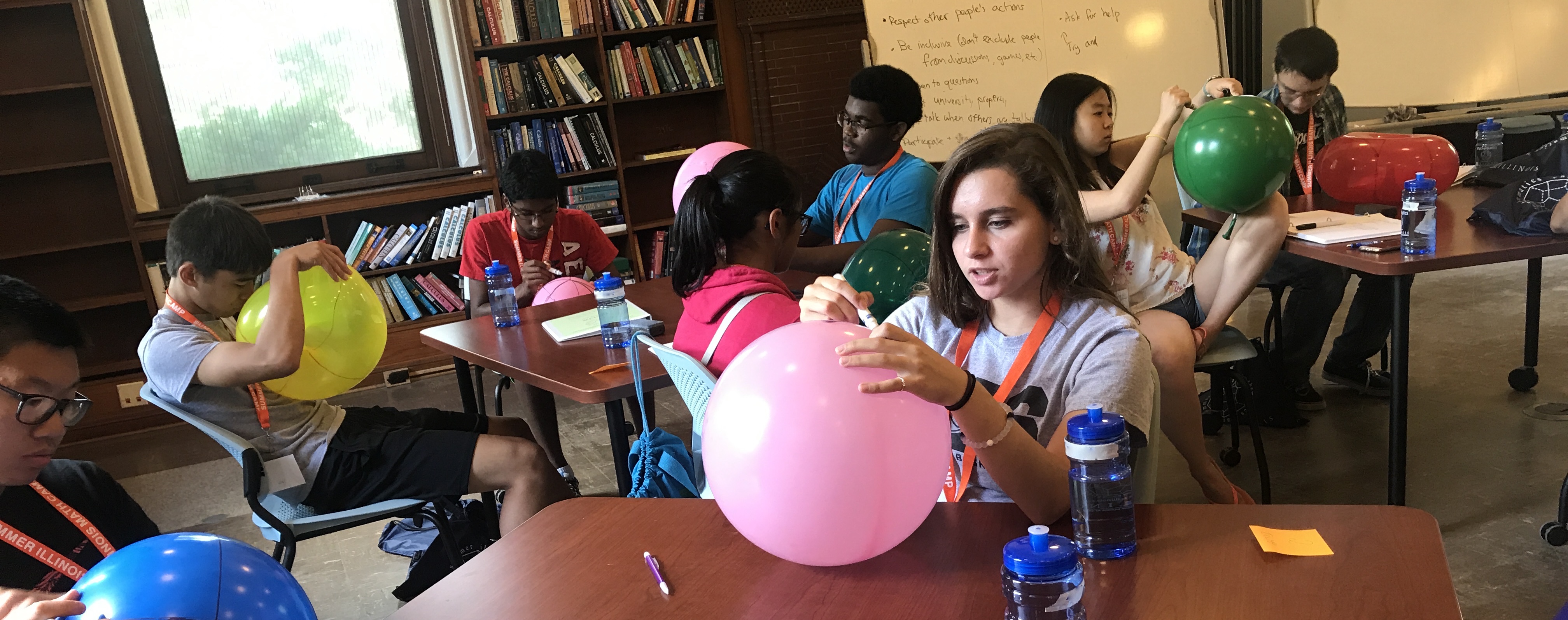 Campers drawing on balloons 