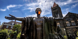 Alma Mater wearing a face covering with Altgeld Hall in the background.