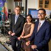 Richard Sowers, Rachneet Kaur and Manuel Hernandez stand next to treadmill in a lab. They are surrounded my monitors, electrical cords, and medical monitoring equipment 